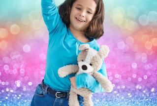 A girl holds a stuffed dog toy and raises one arm above her head