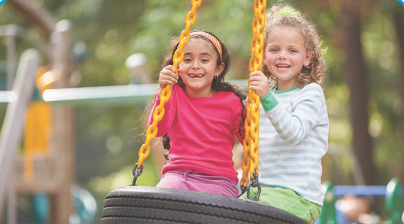 two kids on a tire swing